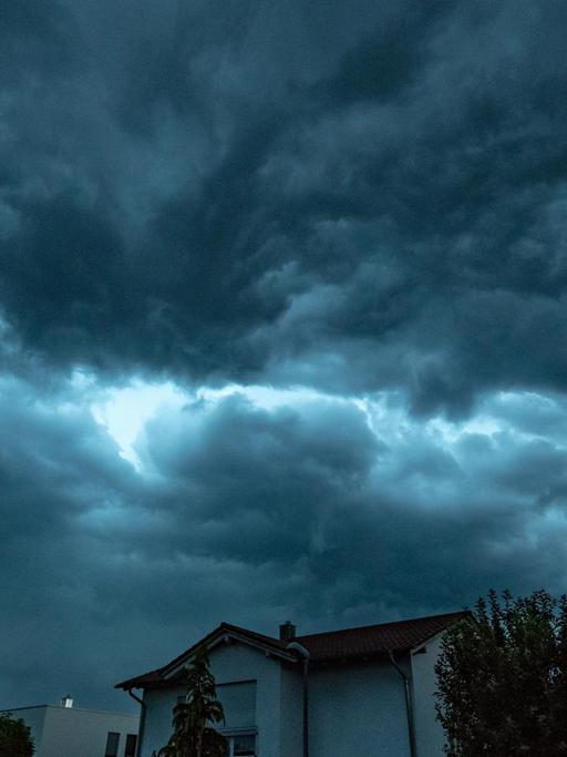 Bayern, Straubing: Dunkle Gewitterwolken ziehen im Abendlicht über ein Wohngebiet.