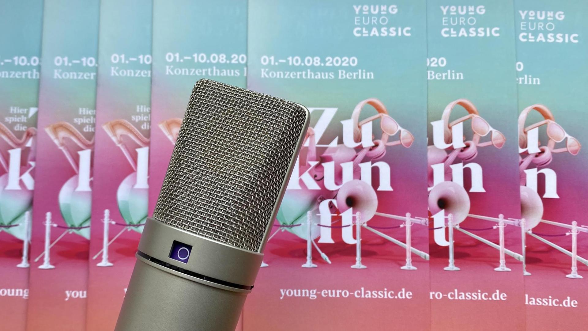 Ein Mikrophon vor den bunten Flyern der Veranstaltungsreihe, das verschiedene Musikinstrumente zeigt. Ein Mikrophon vor den bunten Flyern der Veranstaltungsreihe, das verschiedene Musikinstrumente zeigt.