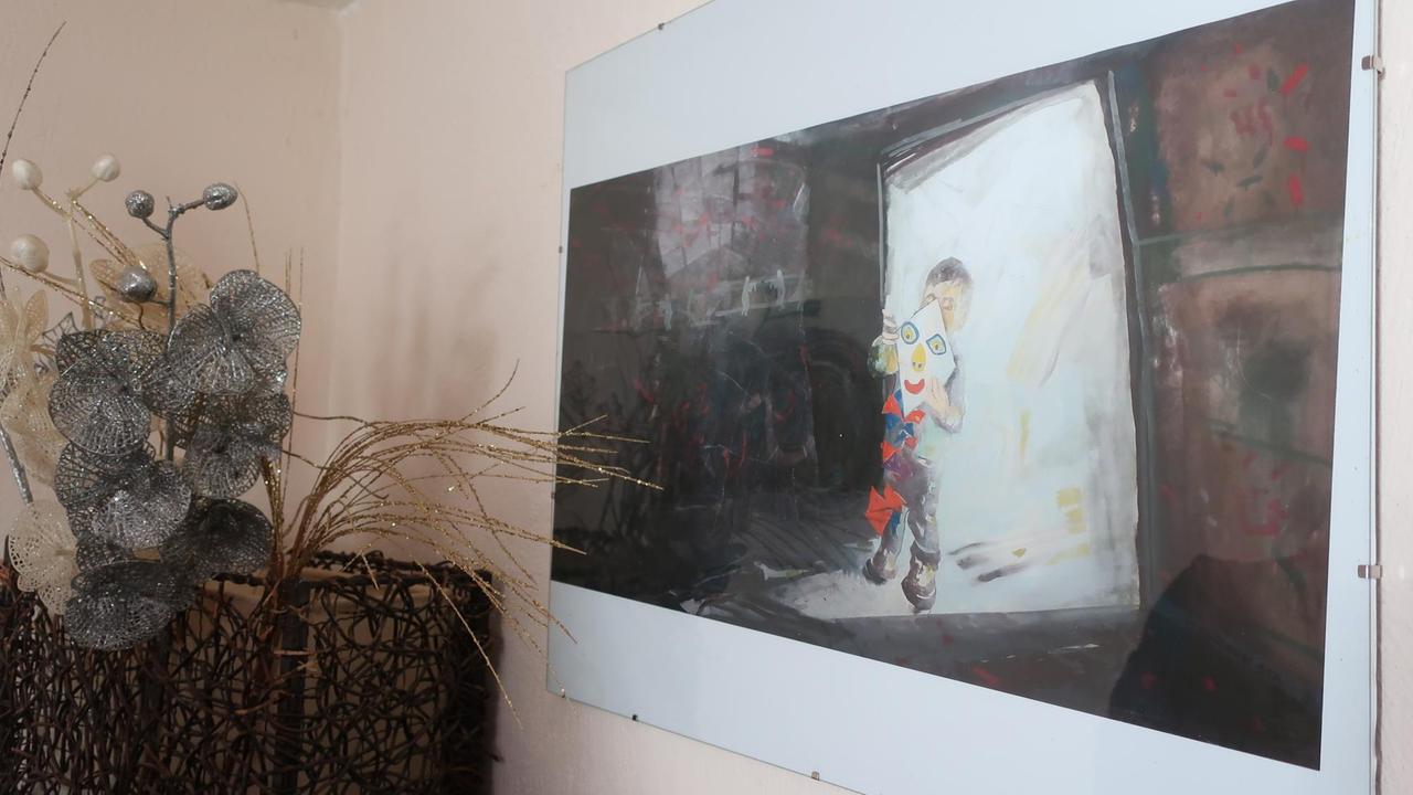 Ein Bild von einem Jungen mit Drachen hängt an einer Wohnzimmerwand Ein Bild von einem Jungen mit Drachen hängt an einer Wohnzimmerwand