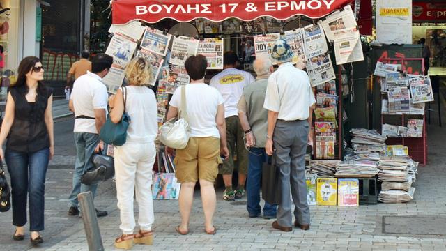 Nach der Einigung in Brüssel: Menschen in Athen lesen an einem Zeitungsstand; Aufnahme vom 13. Juli 2015