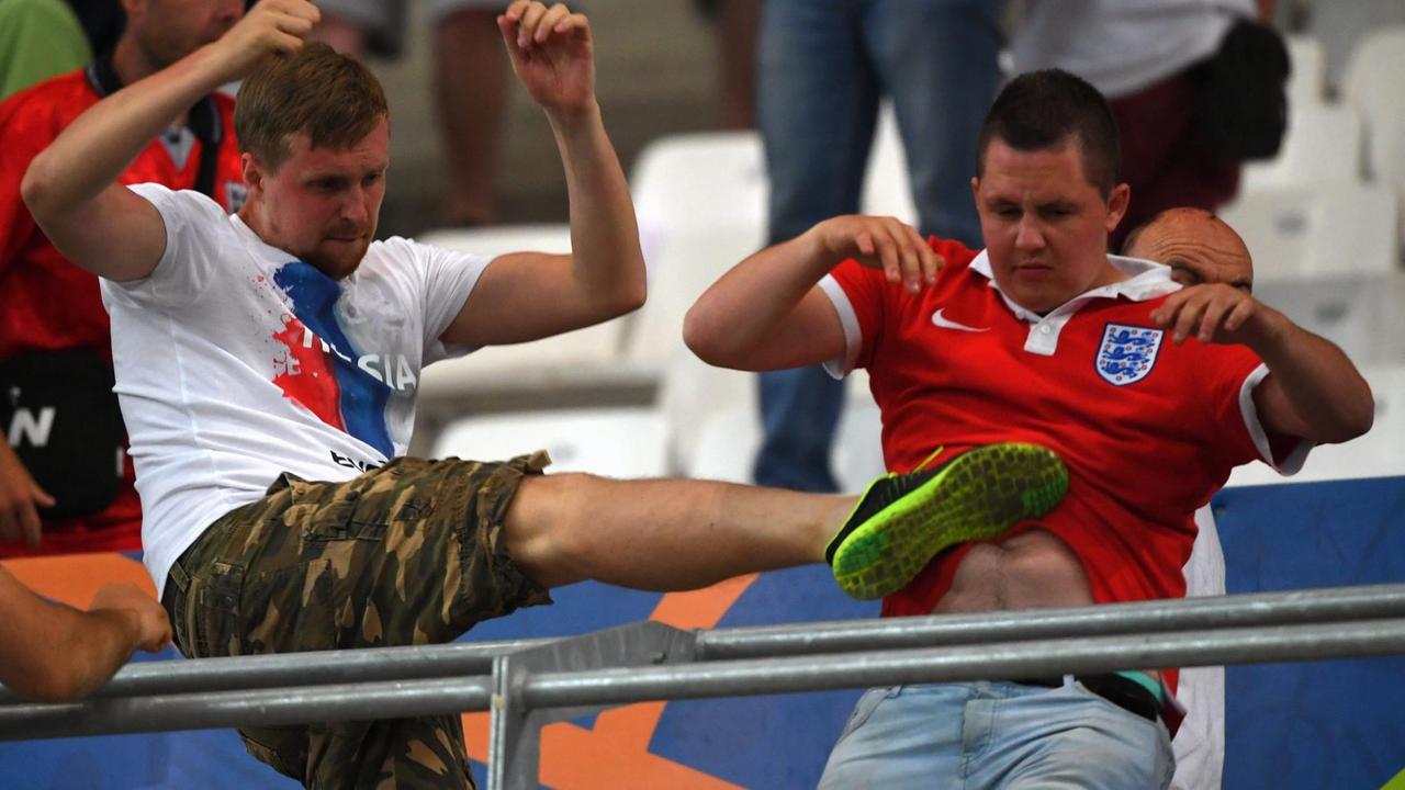 Ein russischer Fan tritt einem englischen Fan gegen den Bauch. Ein russischer Fan tritt einem englischen Fan gegen den Bauch.