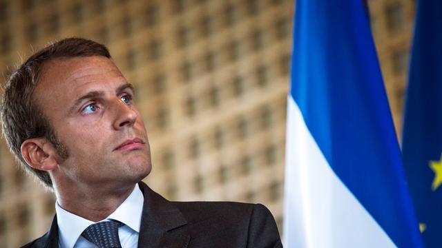 Frankreichs Wirtschaftminister Emmanuel Macron, im Hintergrund eine Fahne