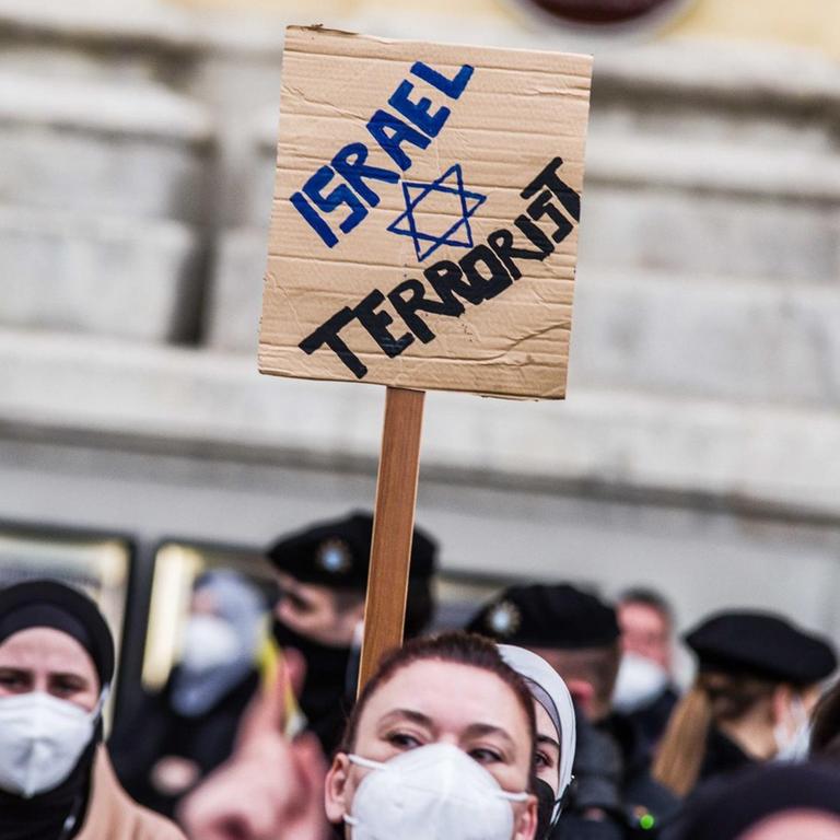 Demonstration gegen die israelische Politik in München - auf einem Plakat werden Israelis mit Terroristen verglichen.
