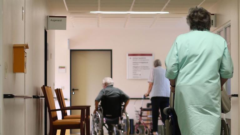 Heike Jakobi vom ehrenamtlichen Kranken-Lotsendienst schiebt einen Patienten zur Therapie im Albertinen-Haus in Hamburg. Heike Jakobi vom ehrenamtlichen Kranken-Lotsendienst schiebt einen Patienten zur Therapie im Albertinen-Haus in Hamburg.