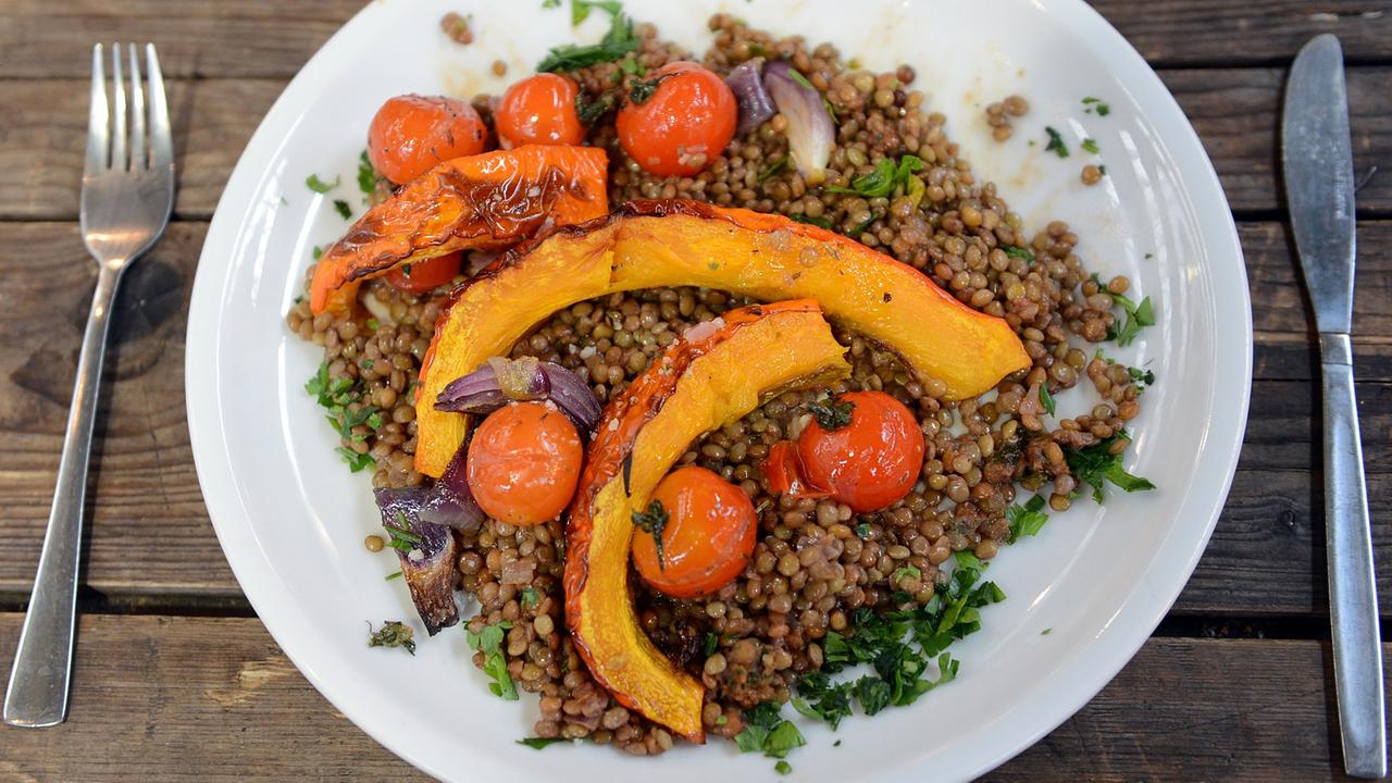 Veganes Essen aus Linsen, Kürbis, Zwiebeln und Tomaten auf einem Teller