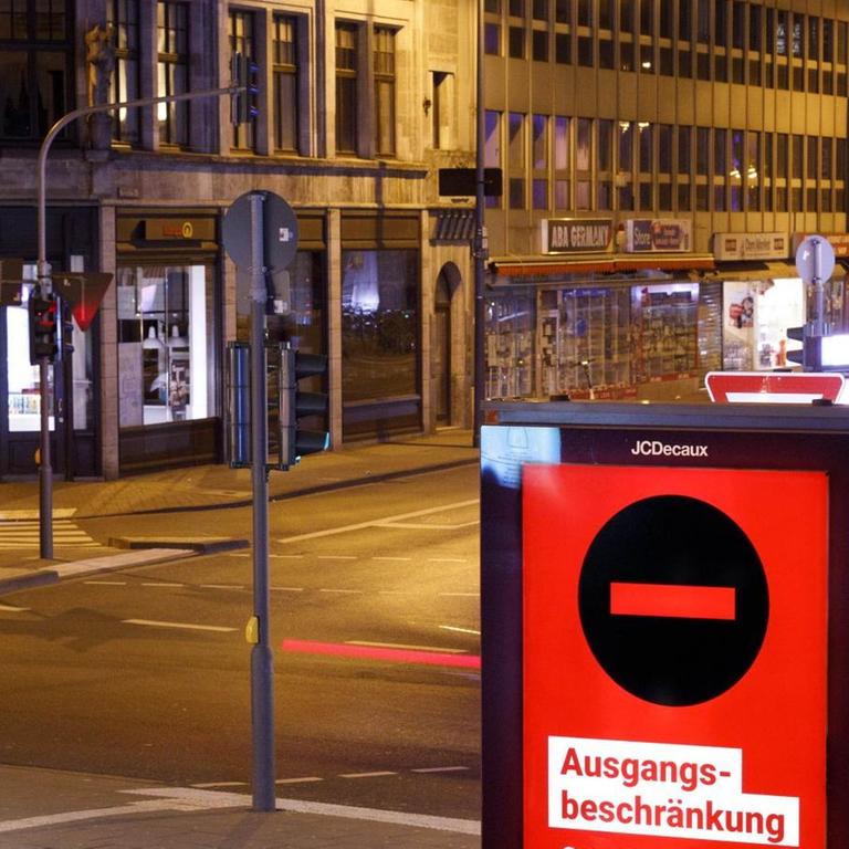 Eine Digitalanzeige in der Kölner Innenstadt weist auf die geltenden r Ausgangsbeschränkungen in der Zeit von 21 Uhr bis 5 Uhr hin