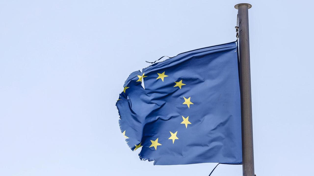 Eine zerrissene EU-Fahne flattert im Wind. Eine zerrissene EU-Fahne flattert im Wind.