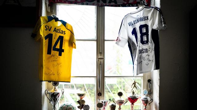 Ein Fußballfan hat all seine Pokale und Trikots vom SV Atlas Delmenhorst und vom VfL Osnabrueck im Fenster drapiert.