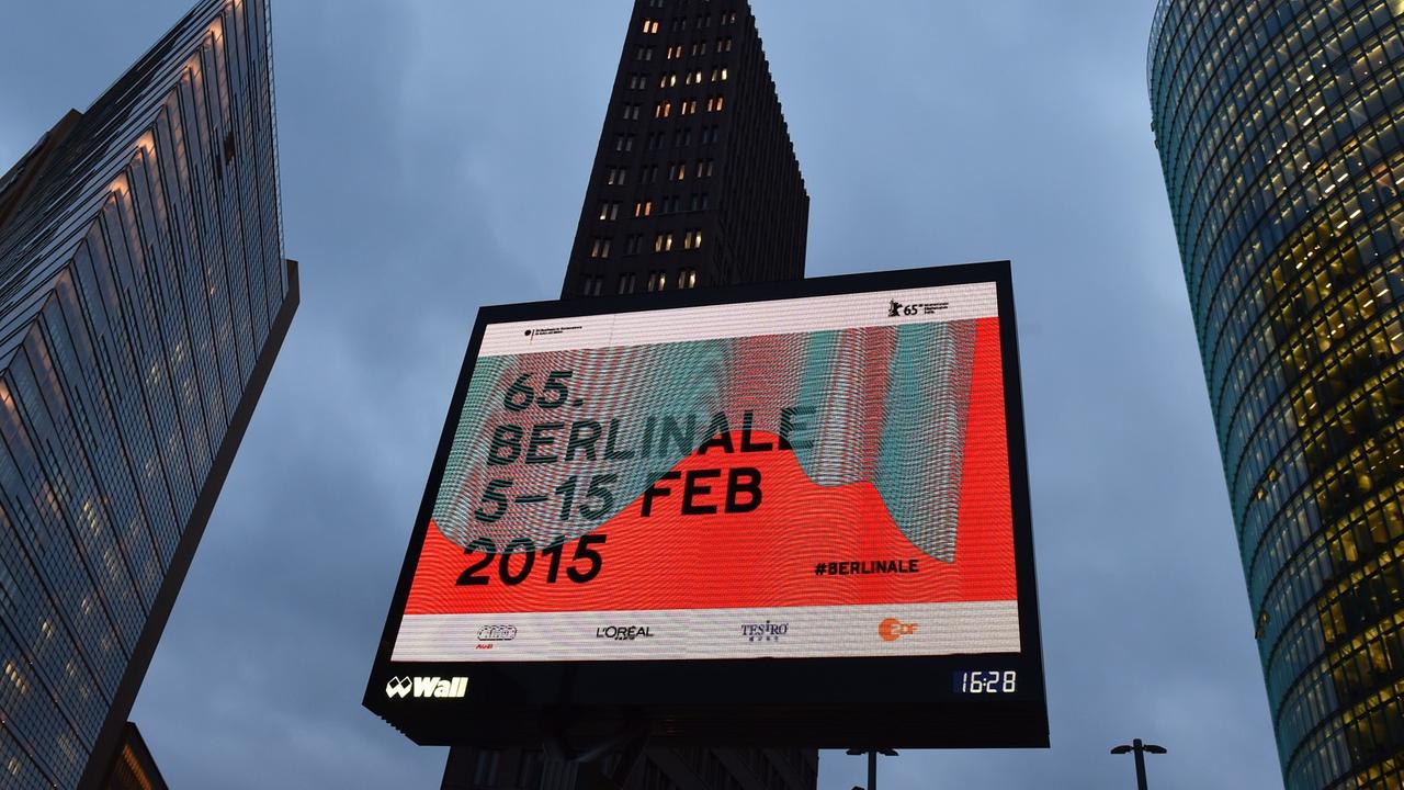 Ein beleuchtetes Plakat, das für die 65. Berlinale wirbt