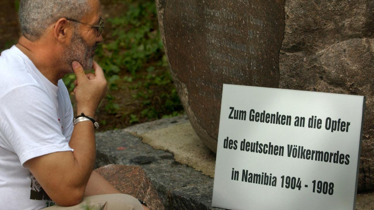 Eine Gedenktafel für die "Opfer des deutschen Völkermordes in Namibia von 1904 bis 1908" betrachtet Israel Kaunatjike, Angehöriger des Herero-Volkes, am Mittwoch (11.08.2004) auf dem Garnisonfriedhof in Berlin. 