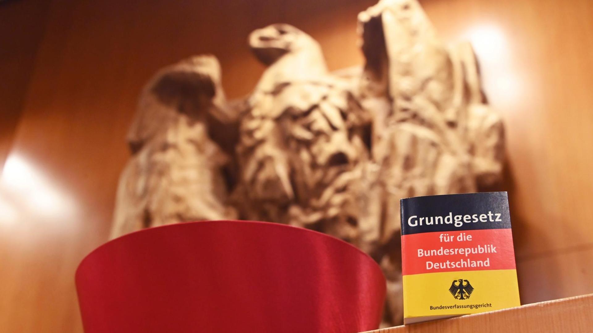Vor dem Bundesadler im Sitzungssaal des Bundesverfassungsgericht steht eine Miniaturausgabe des Grundgesetz für die Bundesrepublik Deutschland sowie ein Barett eines Bundesverfassungsrichters. Im September 2021 feiert das Bundesverfassungsgericht seinen 70. Geburtstag. Vor dem Bundesadler im Sitzungssaal des Bundesverfassungsgericht steht eine Miniaturausgabe des Grundgesetz für die Bundesrepublik Deutschland sowie ein Barett eines Bundesverfassungsrichters. Im September 2021 feiert das Bundesverfassungsgericht seinen 70. Geburtstag.