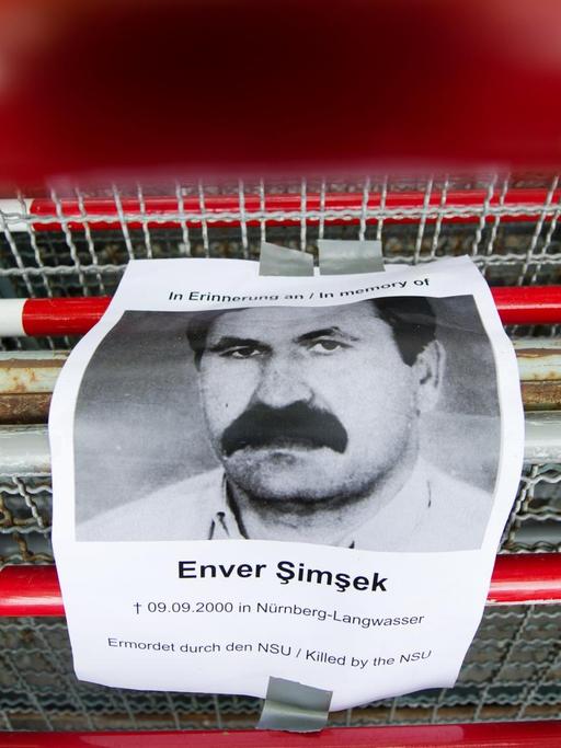 Ein Bild von Enver Şimşek hängt an einem Absperrgitter während des NSU-Prozesses in München.