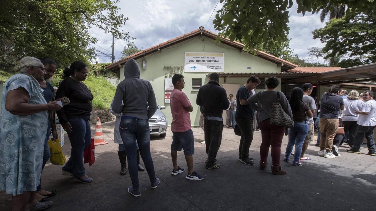 Menschen stehen in einer Schlange und warten auf eine Impfung gegen Gelbfieber Menschen stehen in einer Schlange und warten auf eine Impfung gegen Gelbfieber