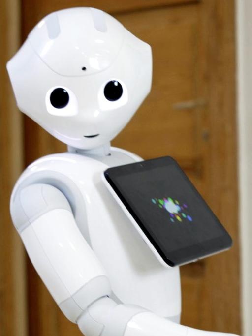 Ein humanoider Roboter mit Kulleraugen und einem integrierten Tablet.