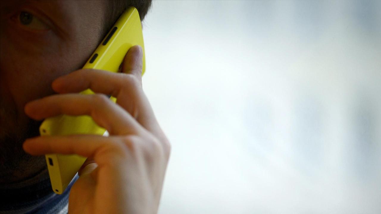Ein Mann telefoniert mit einem Smartphone mit Windows-Betriebssystem Ein Mann telefoniert mit einem Smartphone mit Windows-Betriebssystem