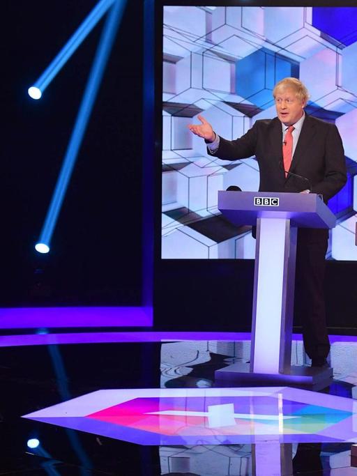 Der Britische Premierminister und Parteichef der Konvervativen Boris Johnson (mitte) bei einer Wahlkampf-TV-Debatte in der BBC mit Labour-Chef Jeremy Corbyn (links).