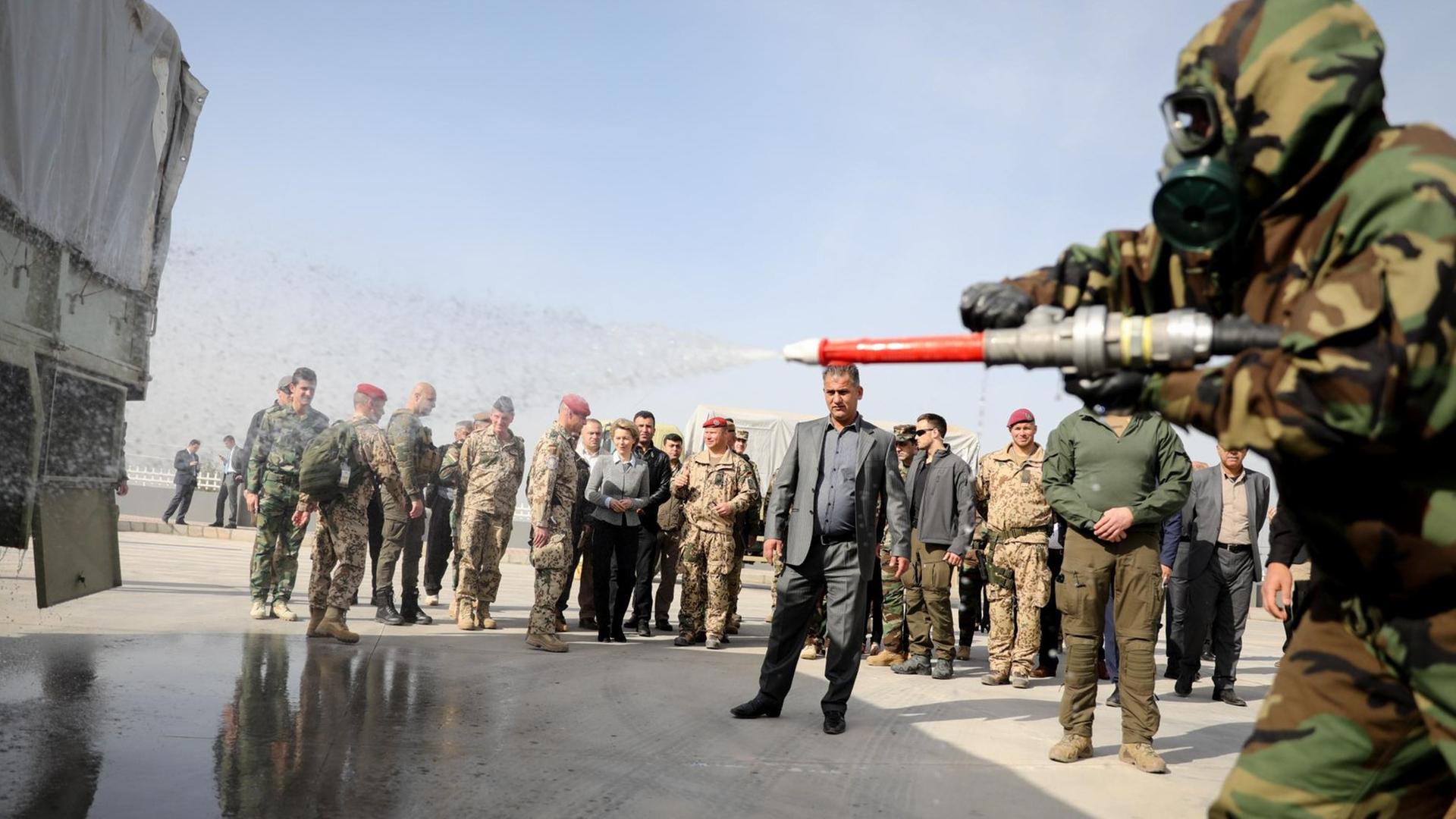 Kurdische Soldaten zeigen bei einer Übung die Dekontamination ihrer ABC-Schutzkleidung