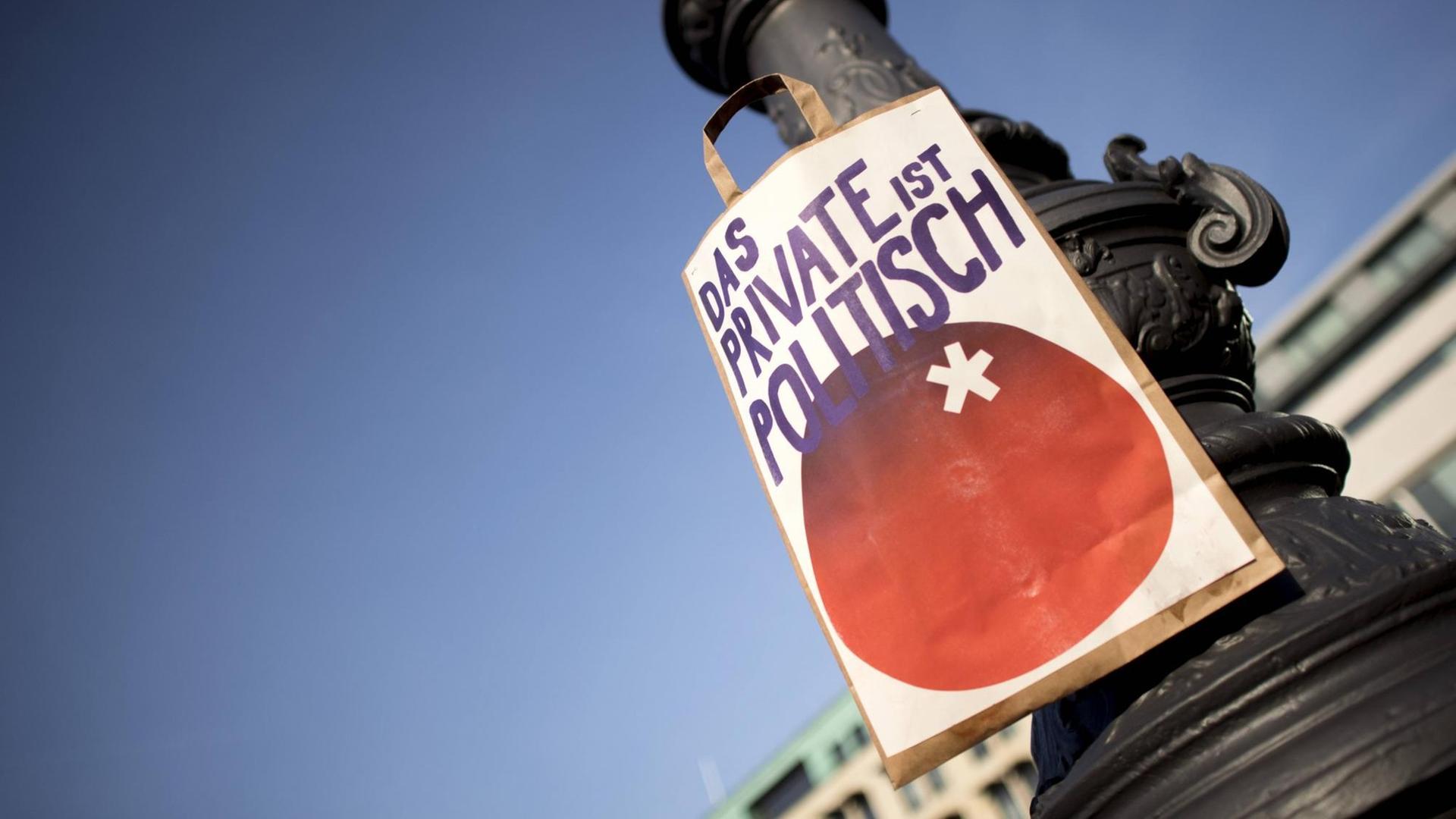 An einem Laternenmast hängt eine Papiertüte auf der gedruckt steht: „Das Private ist politisch”. An einem Laternenmast hängt eine Papiertüte auf der gedruckt steht: „Das Private ist politisch”.