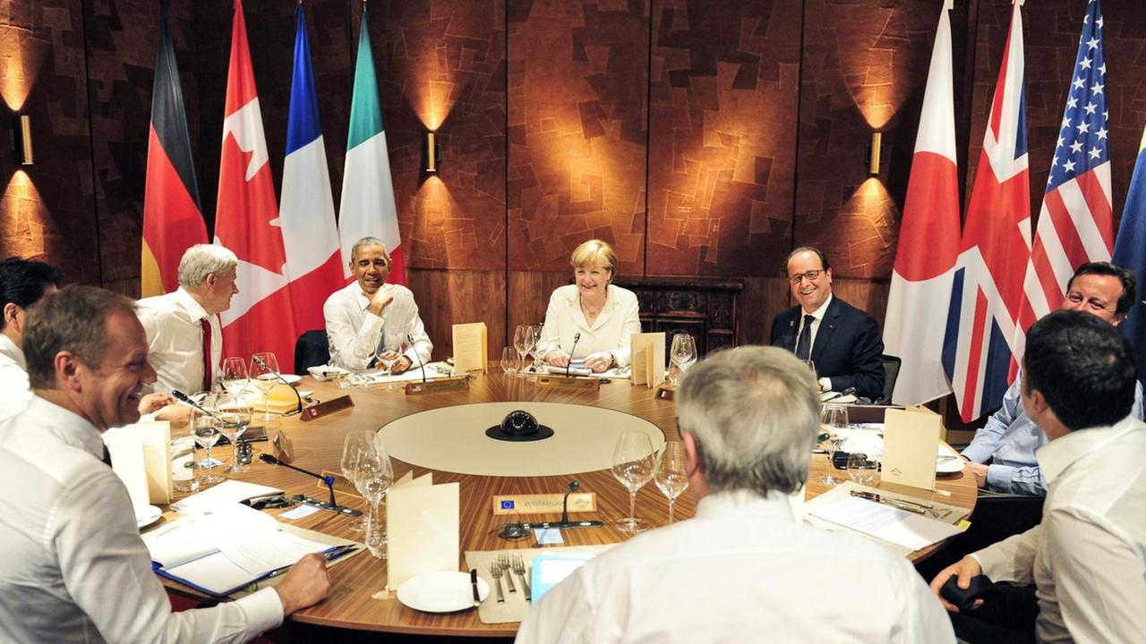 EU-Ratspräsident Donald Tusk (vorne links) und EU-Kommissionspräsident Jean-Claude Juncker sitzen mit den G7-Staats- und Regierungschefs am Tisch. EU-Ratspräsident Donald Tusk (vorne links) und EU-Kommissionspräsident Jean-Claude Juncker sitzen mit den G7-Staats- und Regierungschefs am Tisch.