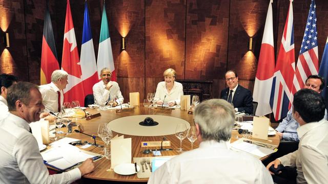 EU-Ratspräsident Donald Tusk (vorne links) und EU-Kommissionspräsident Jean-Claude Juncker sitzen mit den G7-Staats- und Regierungschefs am Tisch.