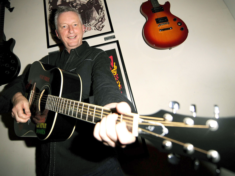 Der Musiker Billy Bragg mit einer Gitarre.