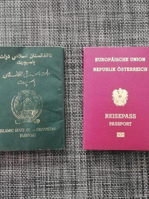 Ein afghanischer und ein österreichischer Pass liegen nebeneinander.