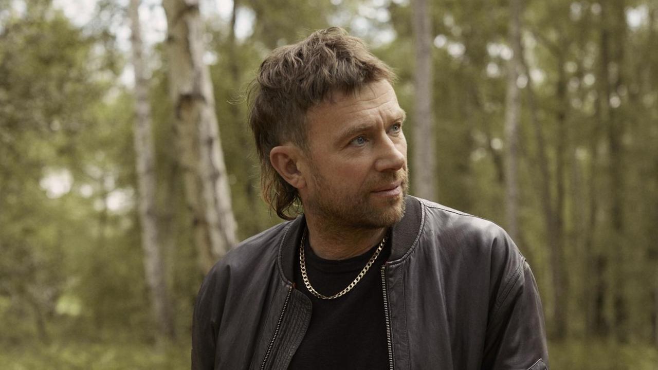 Damon Albarn mit Vokuhila und goldener Kette im Wald Damon Albarn mit Vokuhila und goldener Kette im Wald