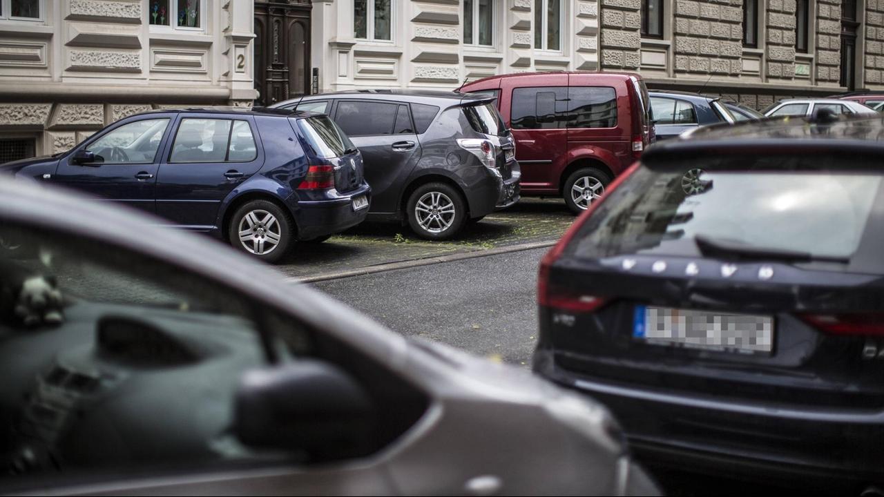 Parkende Autos in Wiesbaden. In einer Straße stehen links und rechts Autos.