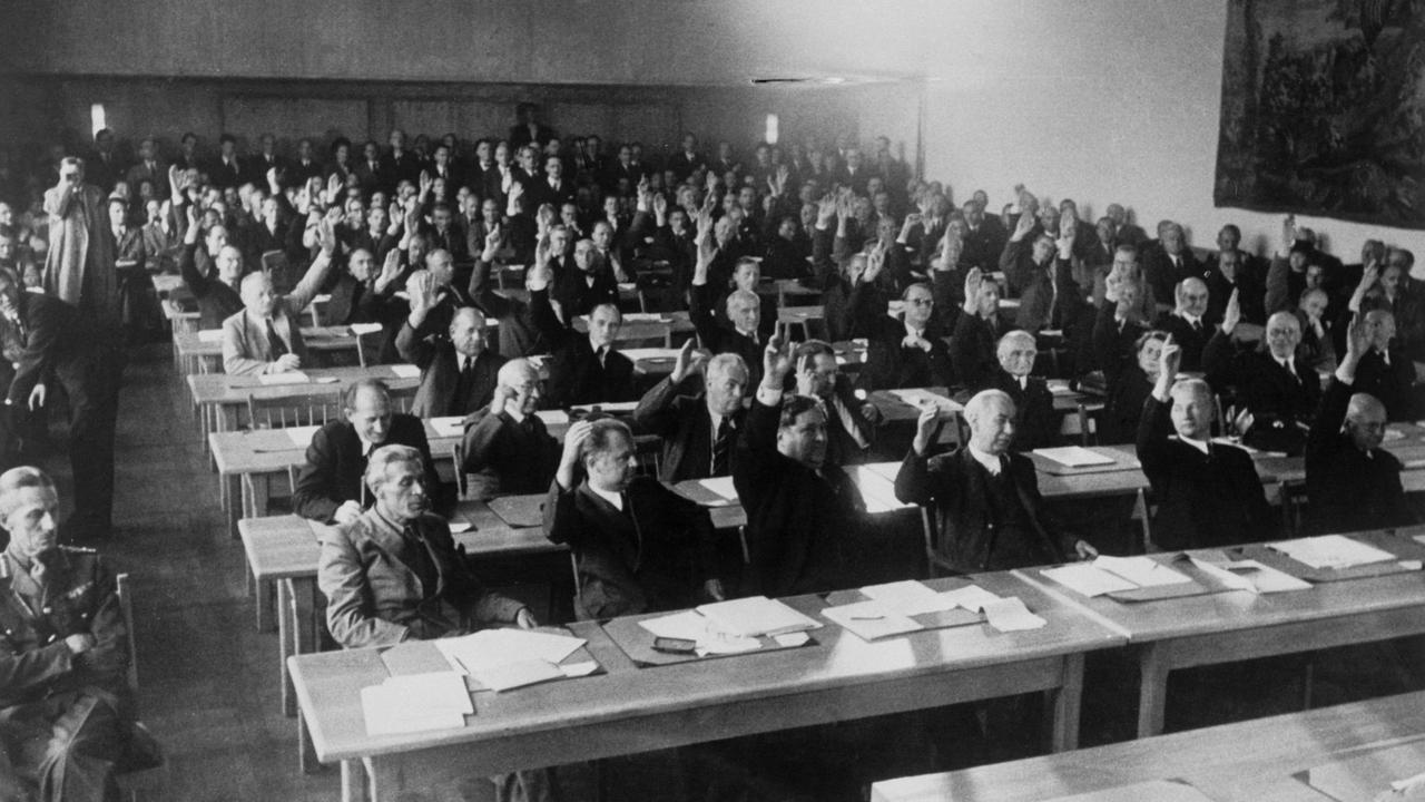 Schwarzweiß-Aufnahme der konstituierenden Sitzung des Parlamentarischen Rates. Zu sehen sind u.a.: 1. Reihe v. li. Max Reimann (KPD), NRW-Innenmin. Menzel, Carlo Schmid, Theodor Heuss. Schwarzweiß-Aufnahme der konstituierenden Sitzung des Parlamentarischen Rates. Zu sehen sind u.a.: 1. Reihe v. li. Max Reimann (KPD), NRW-Innenmin. Menzel, Carlo Schmid, Theodor Heuss.