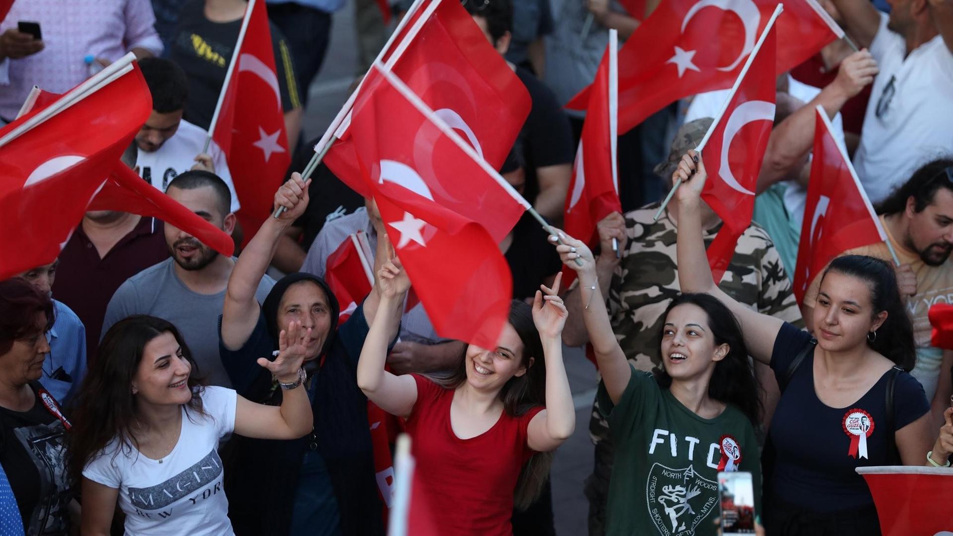 Anhängerinnen von Ekrem Imamoglu schwingen türkische Flaggen und feiern den Wahlausgang Anhängerinnen von Ekrem Imamoglu schwingen türkische Flaggen und feiern den Wahlausgang