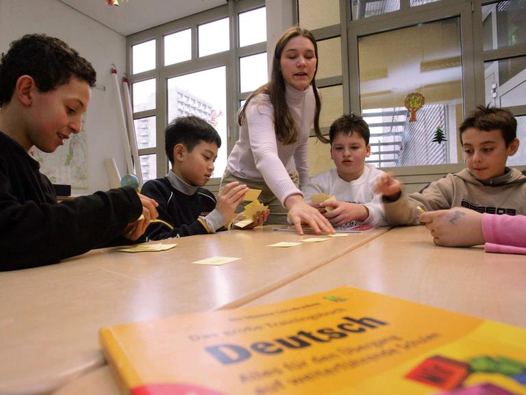 Eine Lehrerin unterrichtet Migrantenkinder in Deutsch