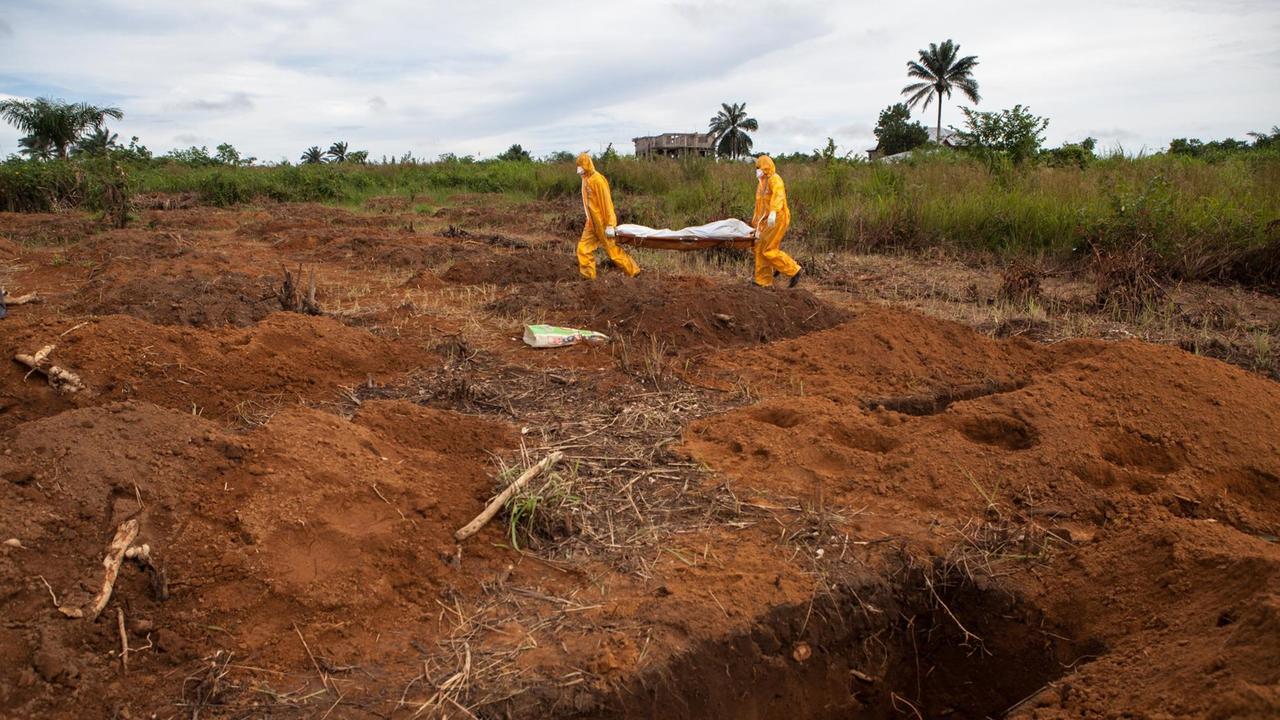 Freiwillige in Schutzanzügen begraben einen Ebola-Toten in Waterloo, 30 Kilometer südostlich von Feetown / Sierra Leone Freiwillige in Schutzanzügen begraben einen Ebola-Toten in Waterloo, 30 Kilometer südostlich von Feetown / Sierra Leone
