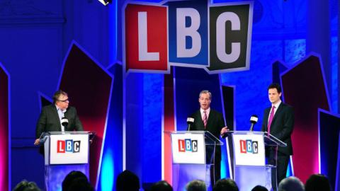 eine blau ausgeleuchtete Bühne mit Nigel Farage (links) im Duell mit Nick Clegg rechts debattieren über Europa.