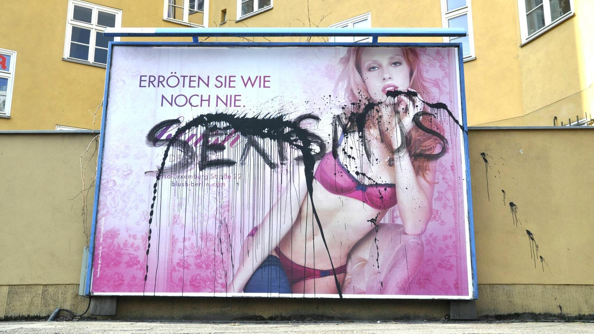 Über ein Plakat, dasss eine Frau in Dessous zeigt steht mit schwarzer Sprühfarbe "Sexismus" geschrieben. Über ein Plakat, dasss eine Frau in Dessous zeigt steht mit schwarzer Sprühfarbe "Sexismus" geschrieben.