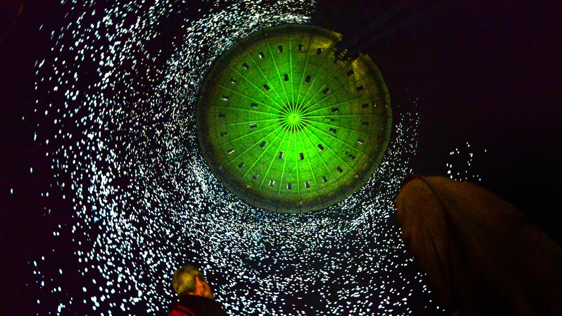 Zwei Medienvertreter betrachten am 10.04.2014 in der Ausstellung "Der schöne Schein" im Gasometer in Oberhausen (Nordrhein-Westfalen) die 100 Meter hohe Installation "320° Licht" von Urbanscreen in den Innenwänden des Gasometers. Zwei Medienvertreter betrachten am 10.04.2014 in der Ausstellung "Der schöne Schein" im Gasometer in Oberhausen (Nordrhein-Westfalen) die 100 Meter hohe Installation "320° Licht" von Urbanscreen in den Innenwänden des Gasometers.