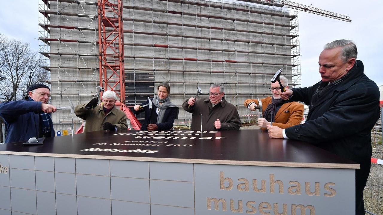 Ehrengäste schlagen am 30.11.2017 zum Richtfest des Neuen Bauhaus-Museum Weimar in Weimar (Thüringen) Nägel in eine Platte - eine alte Tradition. Ehrengäste schlagen am 30.11.2017 zum Richtfest des Neuen Bauhaus-Museum Weimar in Weimar (Thüringen) Nägel in eine Platte - eine alte Tradition.
