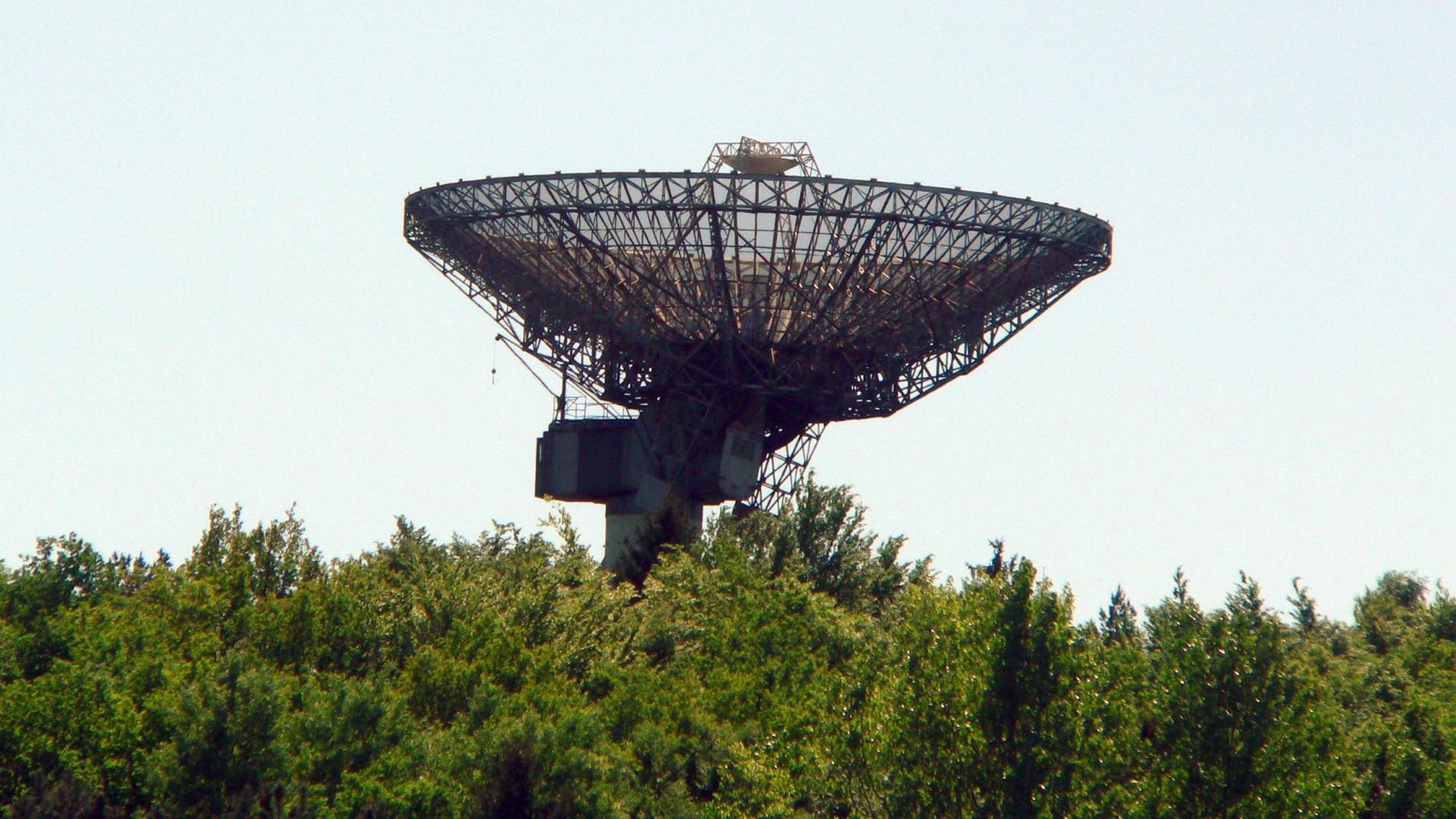 Das historische Radioteleskop auf dem Berg Stockert zwischen grünen Sträuchern und Bäumen.