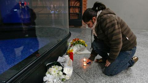 Eine Frau zündet am Madrider Bahnhof Atocha eine Kerze an.
