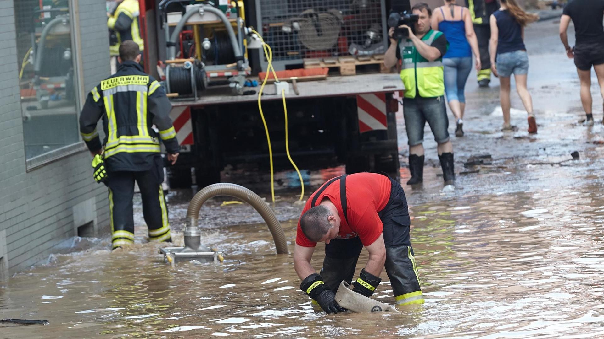 Anwohner und Helfer beseitigen am 24.06.2016 in Stromberg (Rheinland-Pfalz) den Schlamm, den ein Unwetter durch Starkregen und Überflutungen verursacht hat. Anwohner und Helfer beseitigen am 24.06.2016 in Stromberg (Rheinland-Pfalz) den Schlamm, den ein Unwetter durch Starkregen und Überflutungen verursacht hat.