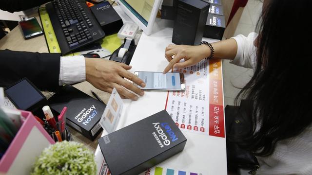 Ein südkoreanischer Kunde hört sich die Präsentation des Verkäufers an, der ihm das neue Samsung Galaxy Note 7 erklärt.