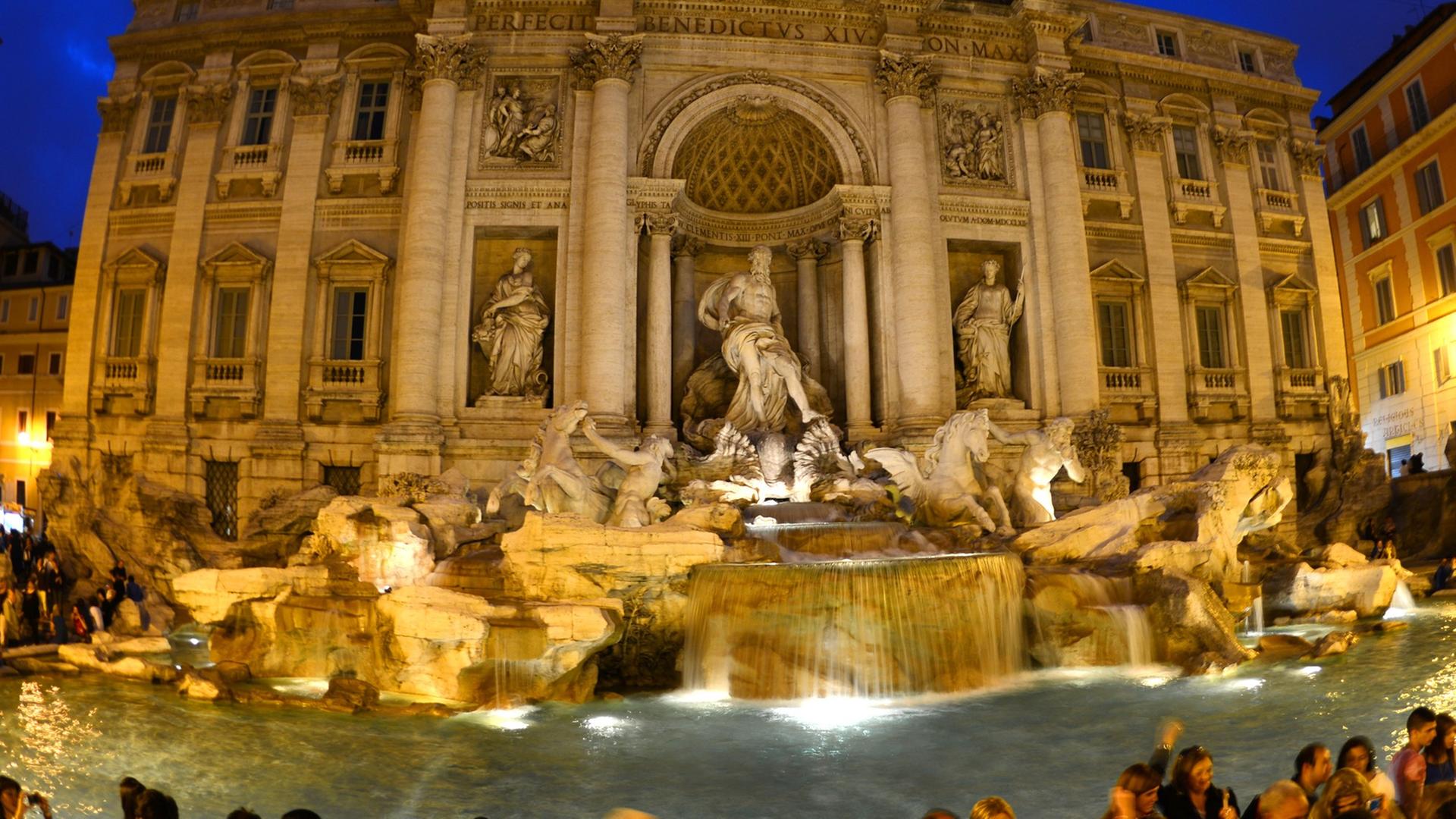 Der Trevi-Brunnen (Fontana del Trevi) in Rom bei Nacht. Der monumentale Barockbrunnen vor dem Palazzo Poli wurde in Anlehnung an Entwürfe Berninis von Nicola Salvi von 1732 bis 1762 im Stil des Spätbarocks im Übergang zum Klassizismus erbaut. Der Trevi-Brunnen (Fontana del Trevi) in Rom bei Nacht. Der monumentale Barockbrunnen vor dem Palazzo Poli wurde in Anlehnung an Entwürfe Berninis von Nicola Salvi von 1732 bis 1762 im Stil des Spätbarocks im Übergang zum Klassizismus erbaut.