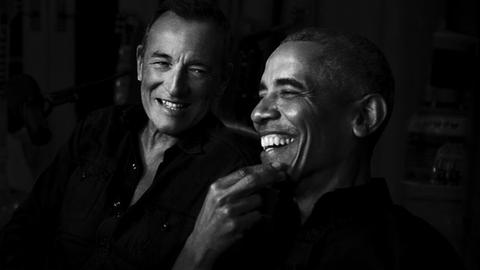 Bruce Springsteen und Barack Obama lachen sich an.