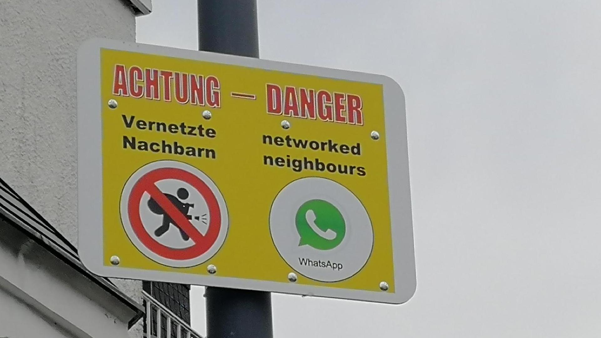Schild mit einer Warnung / Nachricht in deutsch und englisch: Achtung Vernetzte Nachbarn und danger networked neighbours Schild mit einer Warnung / Nachricht in deutsch und englisch: Achtung Vernetzte Nachbarn und danger networked neighbours