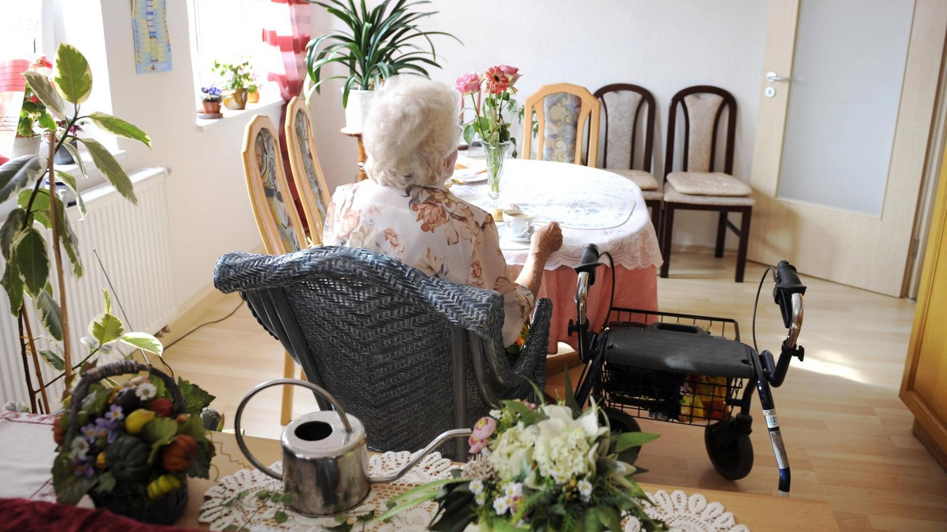 Seniorin sitzt alleine vor einer Tasse Kaffee Seniorin sitzt alleine vor einer Tasse Kaffee