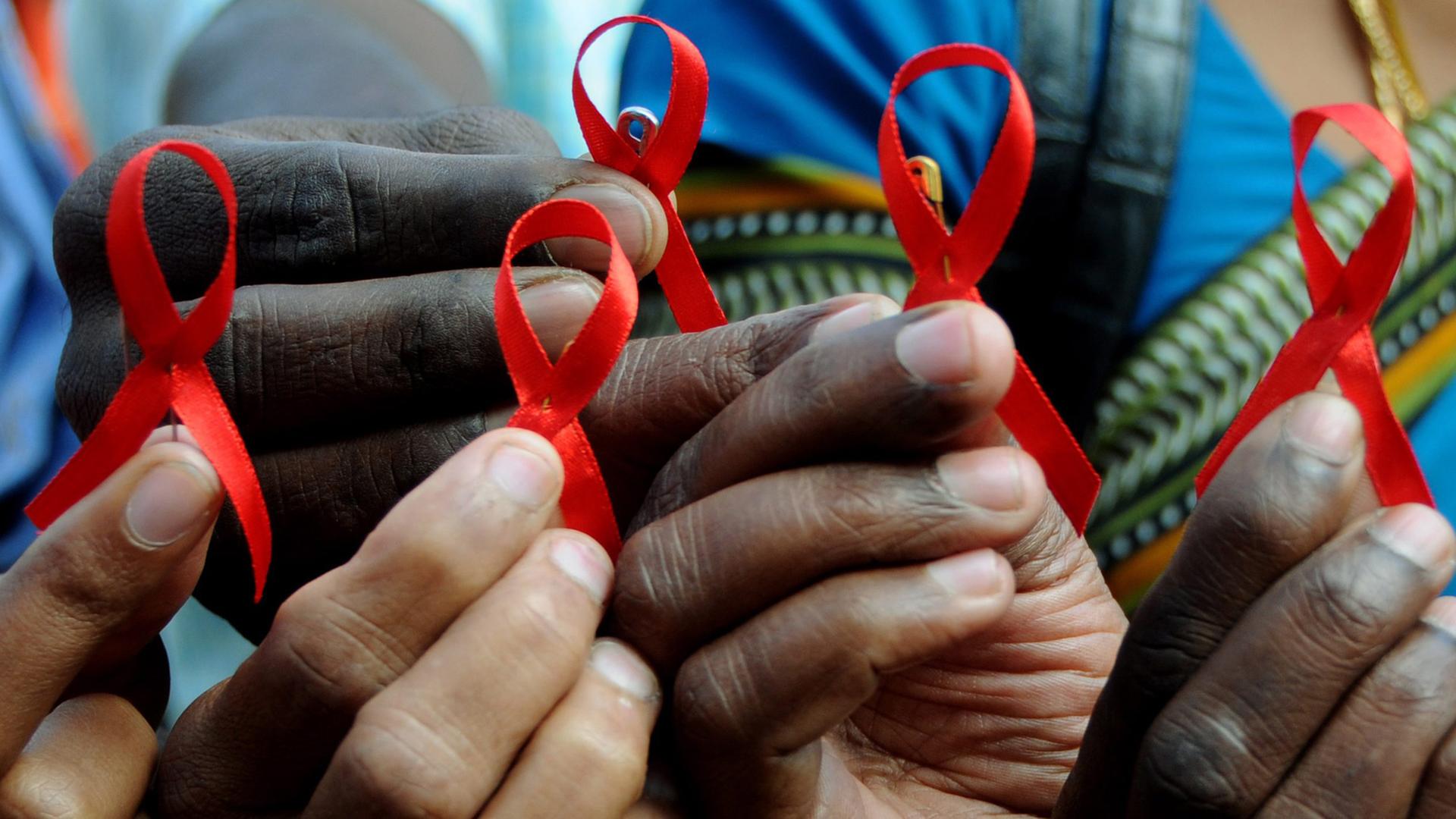 Indische Aktivisten halten am Welt-Aids-Tag am 01.12.2009 in Bangalore im Süden von Indien die Rote Schleife in den Händen. Indische Aktivisten halten am Welt-Aids-Tag am 01.12.2009 in Bangalore im Süden von Indien die Rote Schleife in den Händen.