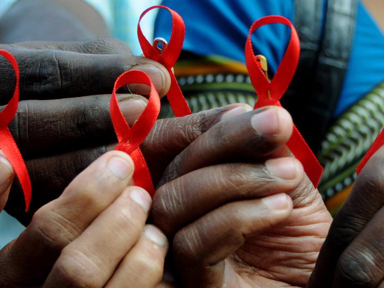 Indische Aktivisten halten am Welt-Aids-Tag am 01.12.2009 in Bangalore im Süden von Indien die Rote Schleife in den Händen.