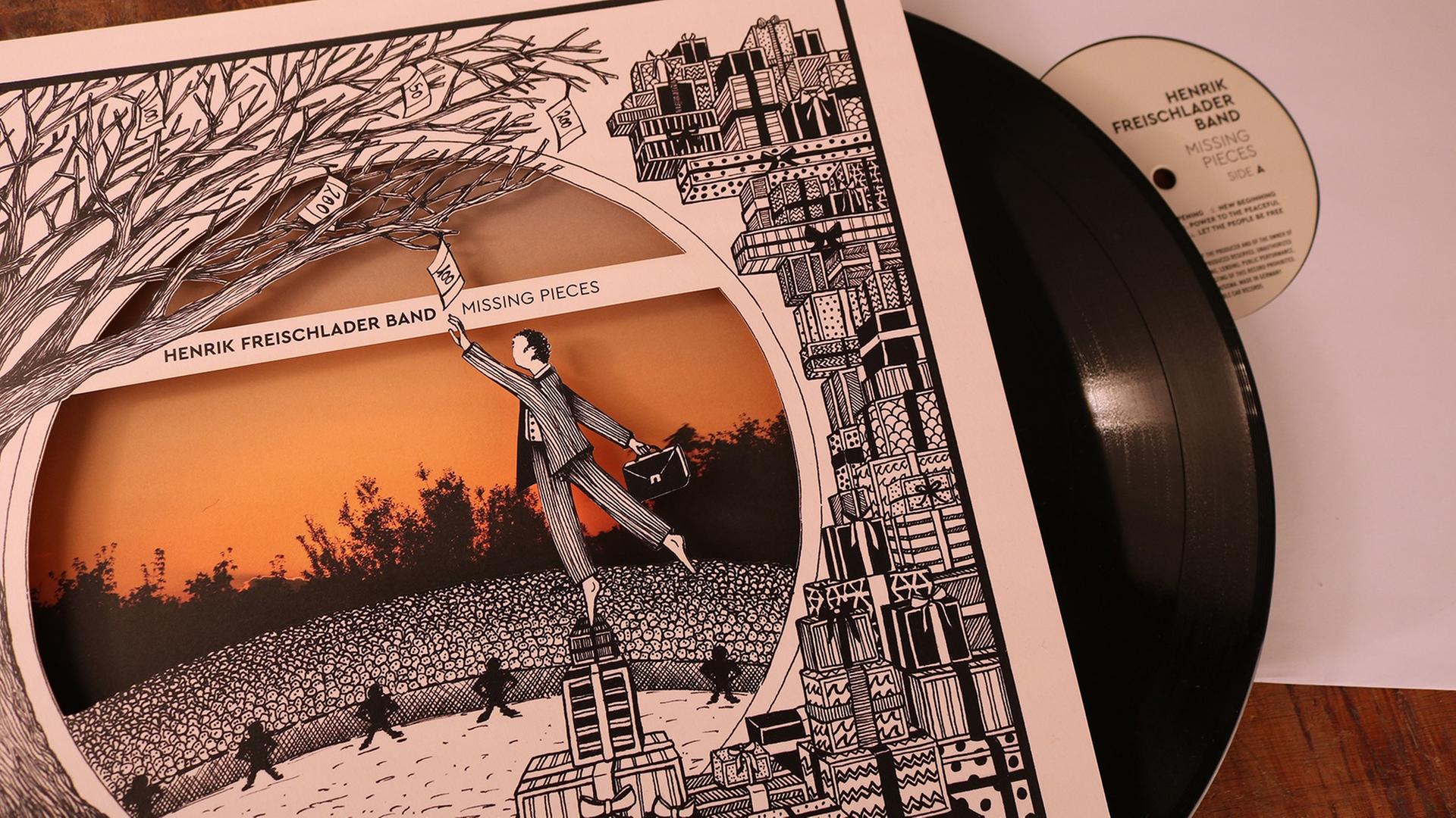 Eine schwarze LP steckt zum Teil in einem Plattencover, auf dem ein gezeichneter Mann zu sehen ist, der mit dem Arm nach oben in einen Baum greift. Eine schwarze LP steckt zum Teil in einem Plattencover, auf dem ein gezeichneter Mann zu sehen ist, der mit dem Arm nach oben in einen Baum greift.