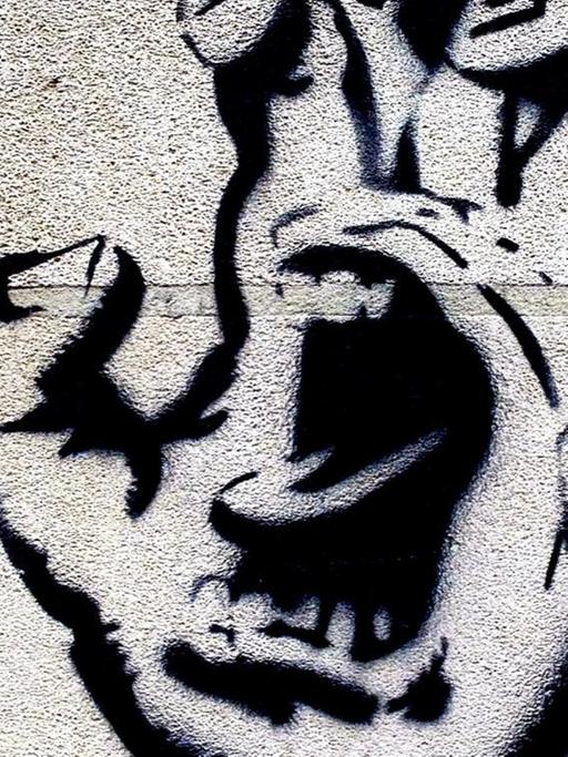 Ein Grafitti zeigt eine Handfläche, in deren Mitte ein Mund aufgerissen schreit.