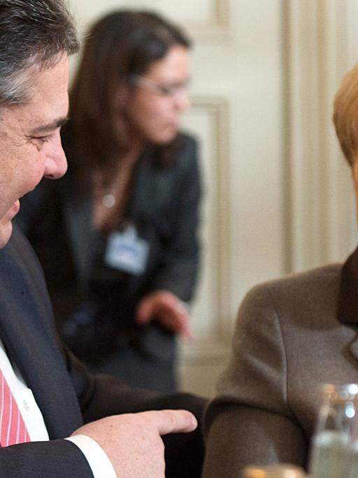 Bundeswirtschaftsminister Sigmar Gabriel (SPD) und Bundeskanzlerin Angela Merkel (CDU) lachen während einer Unterhaltung in Meseberg (Brandenburg) bei der Klausurtagung des Bundeskabinetts.