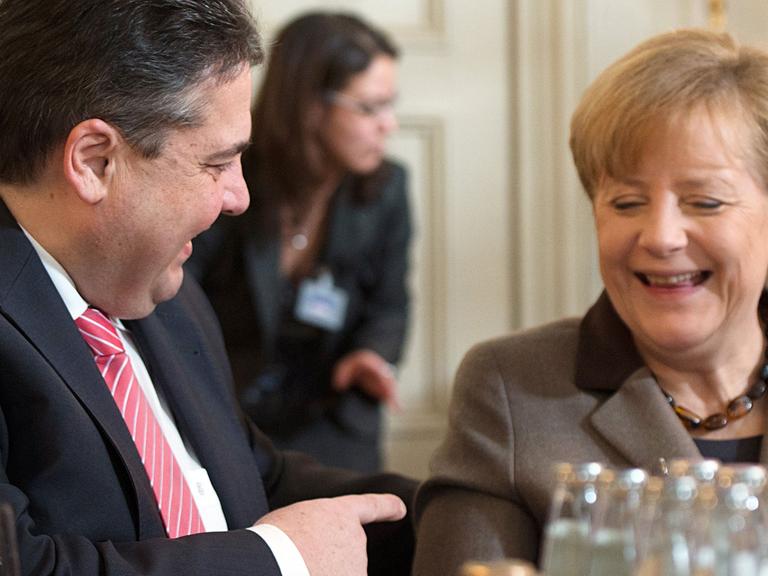 Bundeswirtschaftsminister Sigmar Gabriel (SPD) und Bundeskanzlerin Angela Merkel (CDU) lachen während einer Unterhaltung in Meseberg (Brandenburg) bei der Klausurtagung des Bundeskabinetts.